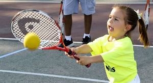Girl hitting tennis ball