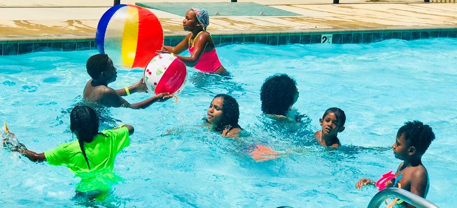 kids playing with ball in pool at pool party